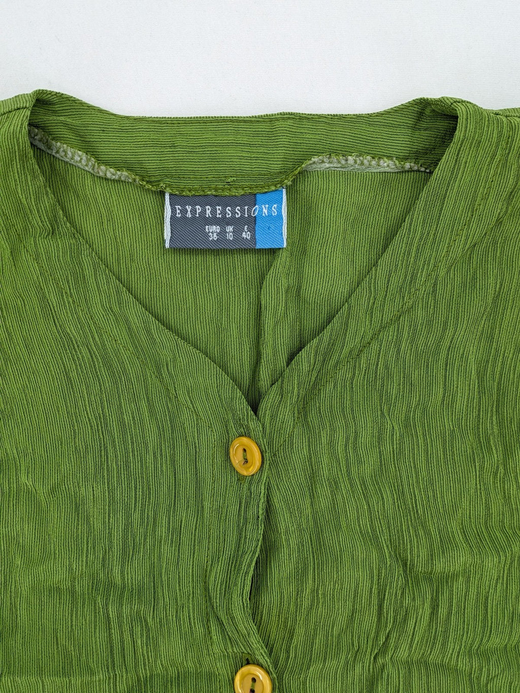 Expressions green blouse with V-neck, button front, and crinkle texture.