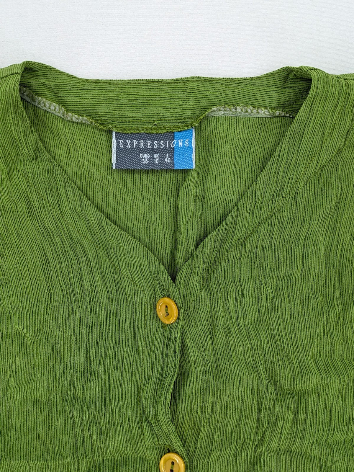 Expressions green blouse with V-neck, button front, and crinkle texture.