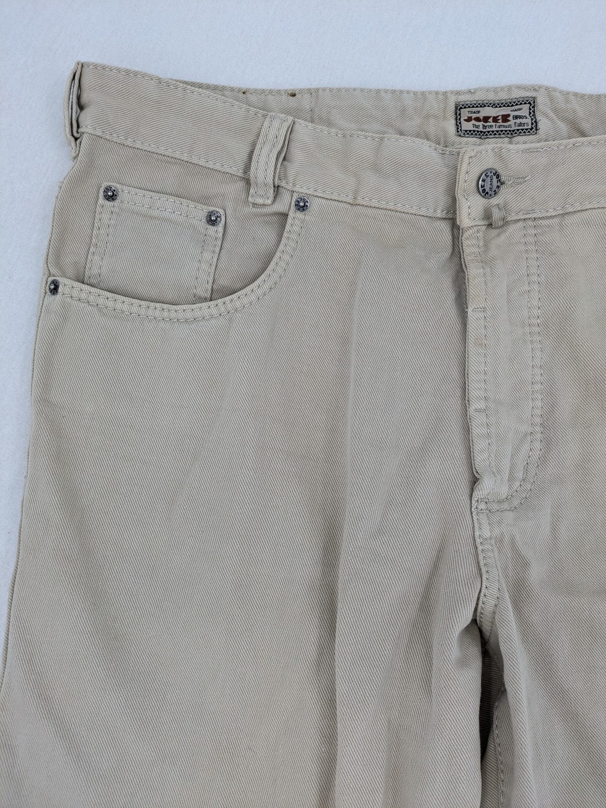 Joker beige straight jeans 5-pocket design with zipper and button closure.