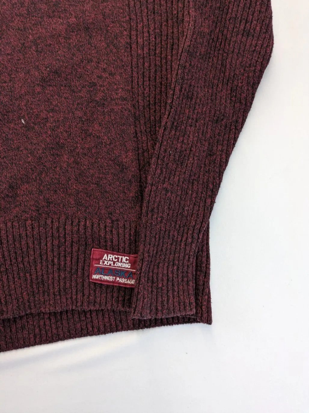 Infinity burgundy turtle neck jumper with quarter-zip and ribbed knit texture.