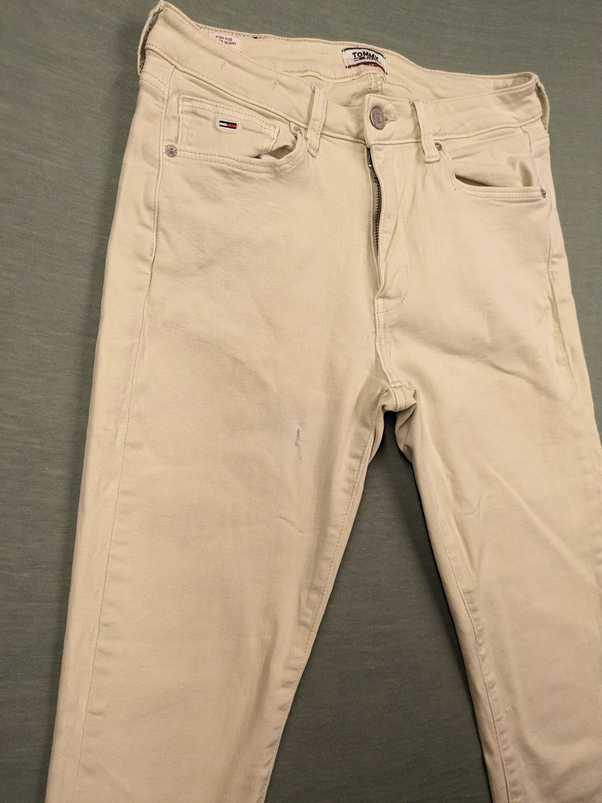 Tommy Jeans beige high rise skinny ankle jeans with logo patch and stretch fabric.