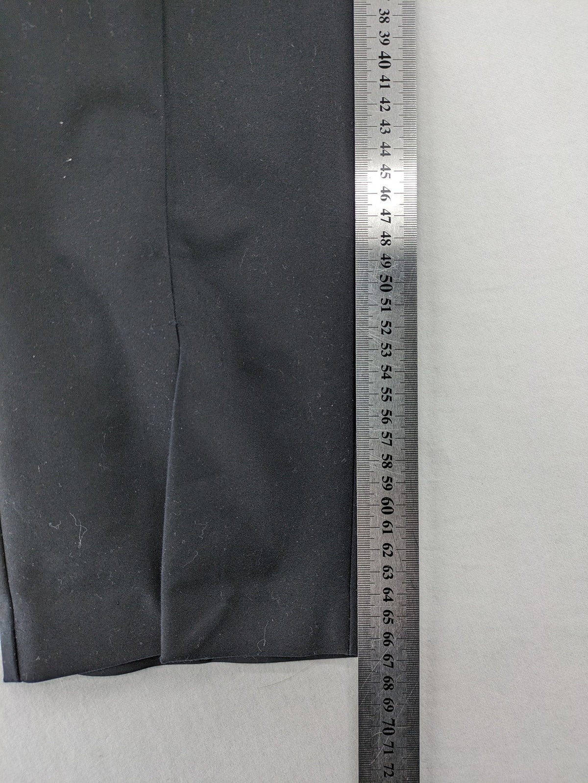 Zara black pants with front creases, subtle slit hem, and buttoned back pocket.