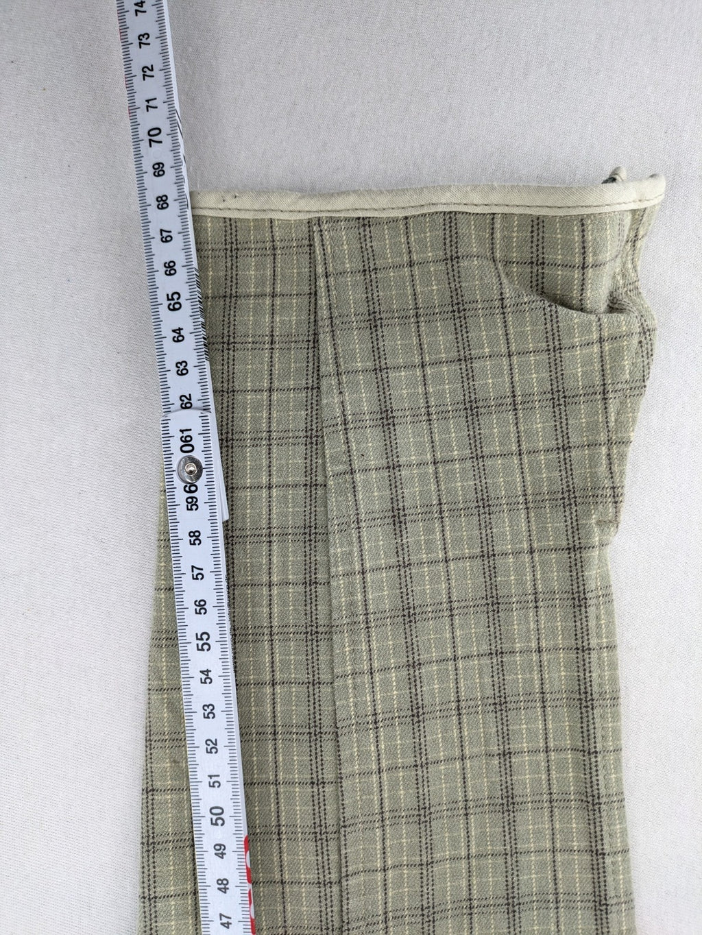 Jodhpur beige and grey riding pants with green check pattern and knee patches.
