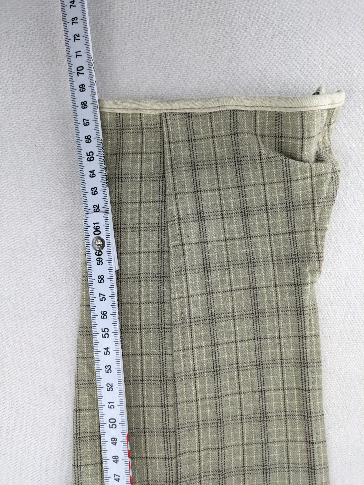Jodhpur beige and grey riding pants with green check pattern and knee patches.