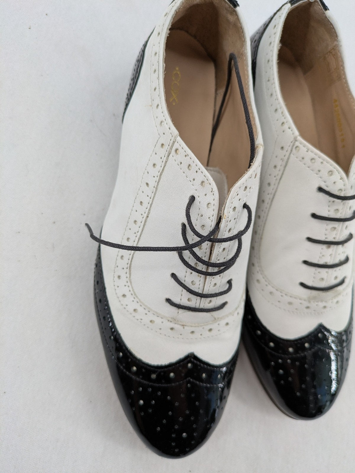 Kontrast black and white deck shoes, glossy patent leather with wingtip cap and brogue detailing.