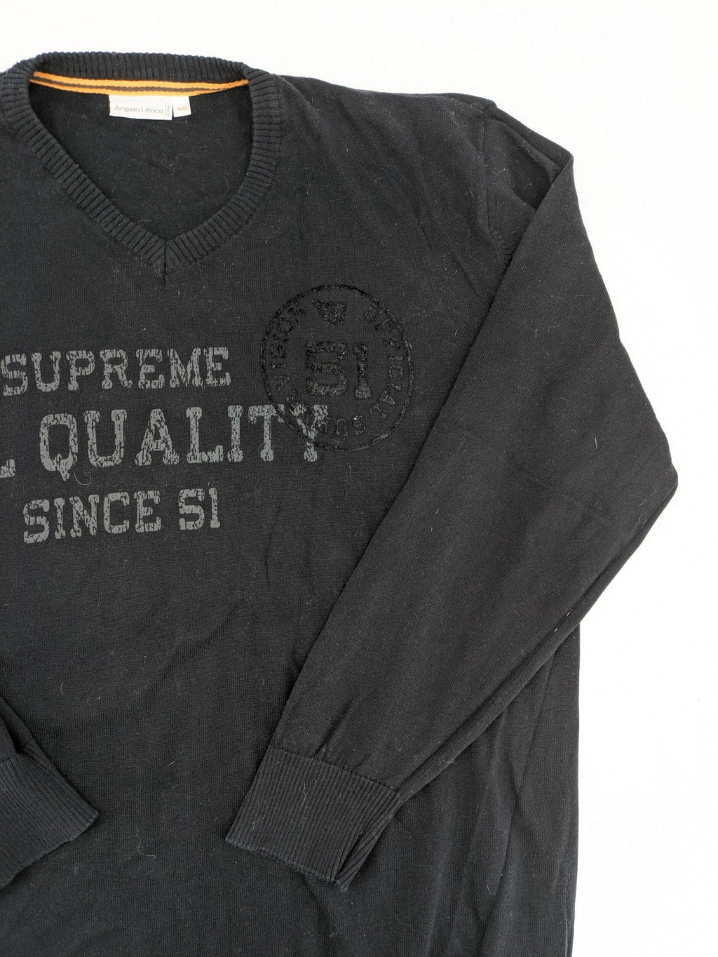 Angelo Litrico black knit jumper V-neck with tonal emblem and "Supreme Oil Quality" graphic.