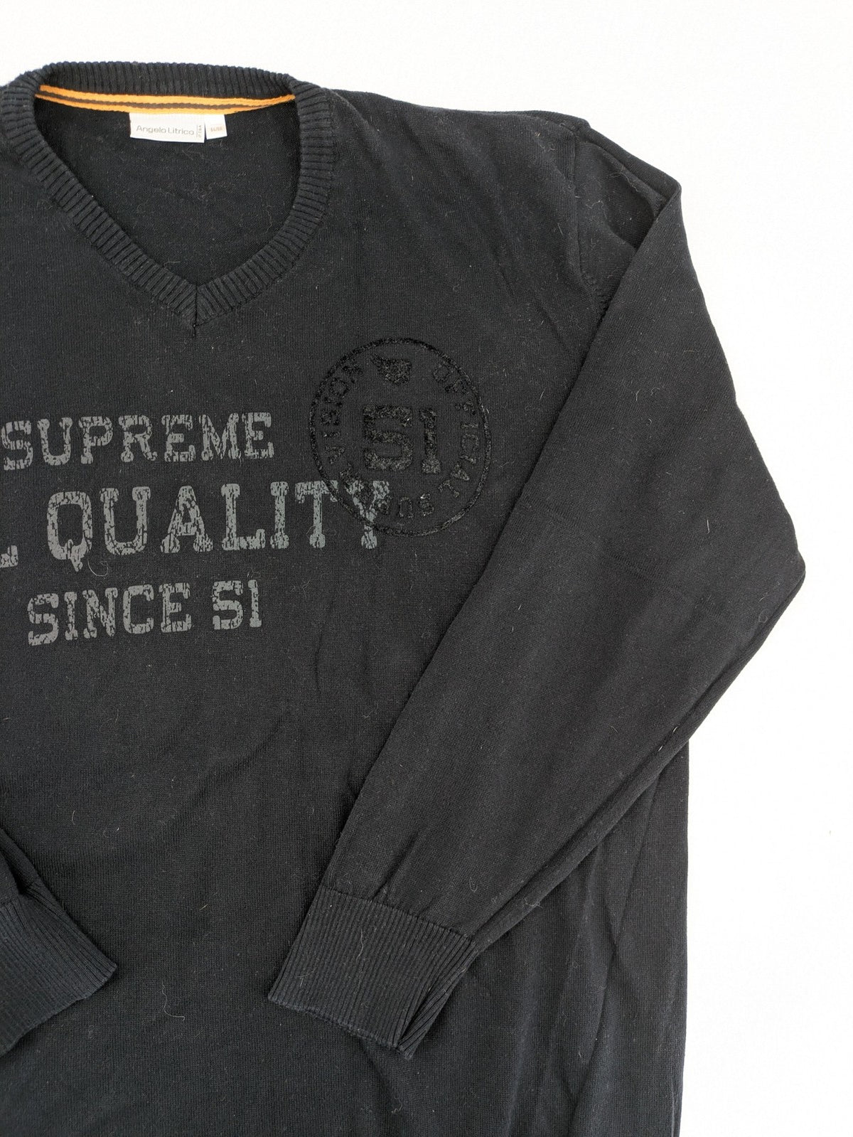 Angelo Litrico black knit jumper V-neck with tonal emblem and "Supreme Oil Quality" graphic.