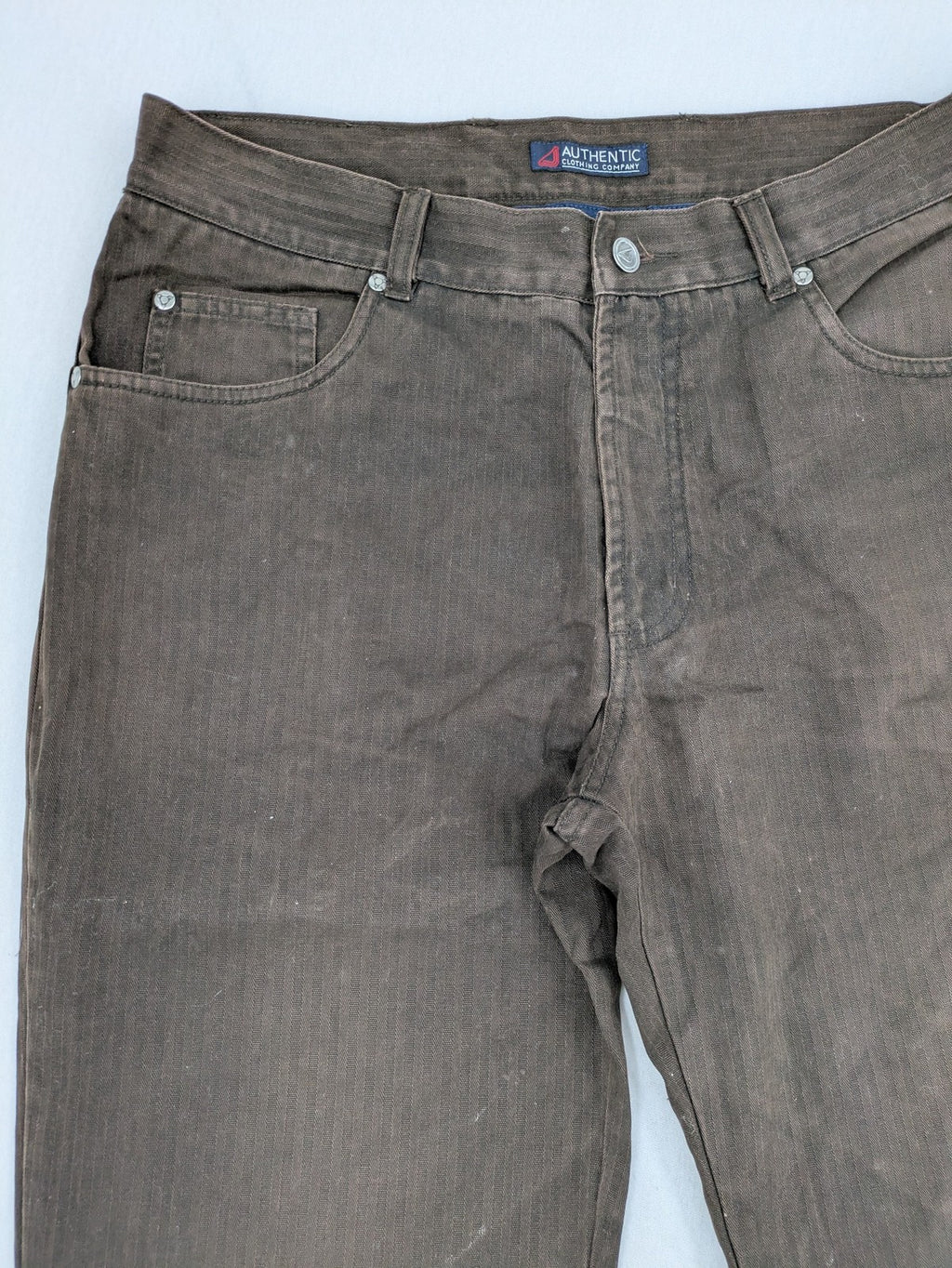 Authentic Clothing Company brown straight jeans with subtle stripe pattern and brand patch.