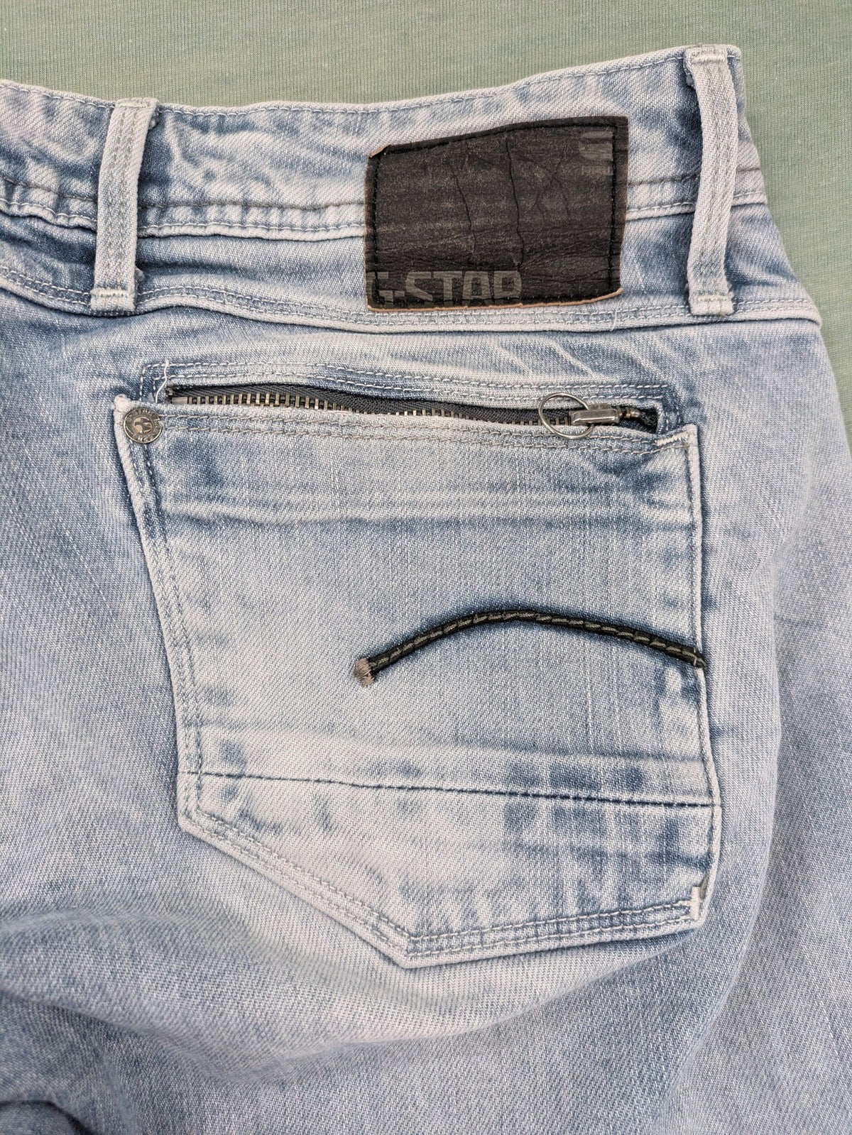 G-Star Raw blue straight leg jeans with classic 5-pocket design and light wash denim.