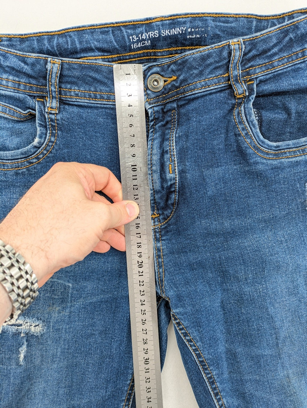 Denim & Co. blue skinny jeans with distressed ripped details and adjustable waistband.