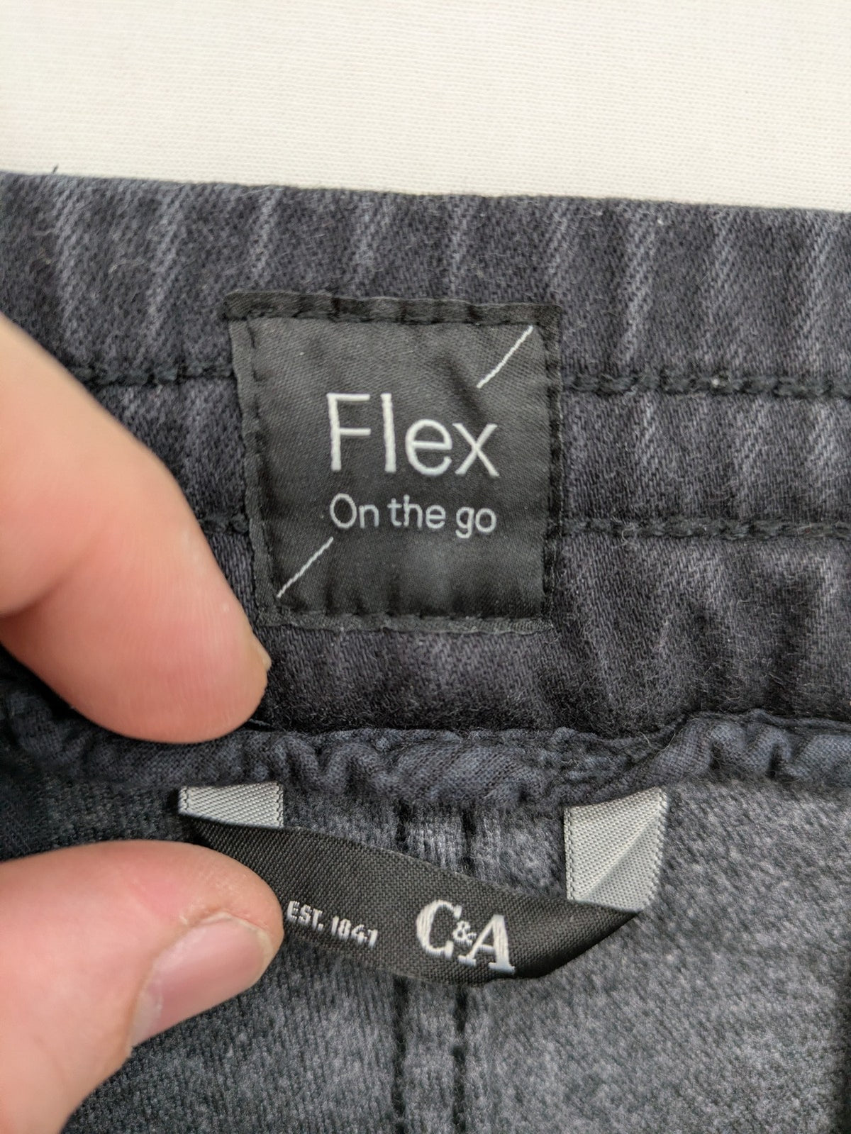 C&A grey jogger pants with elastic cuffs, drawstring waist, and multiple pockets.