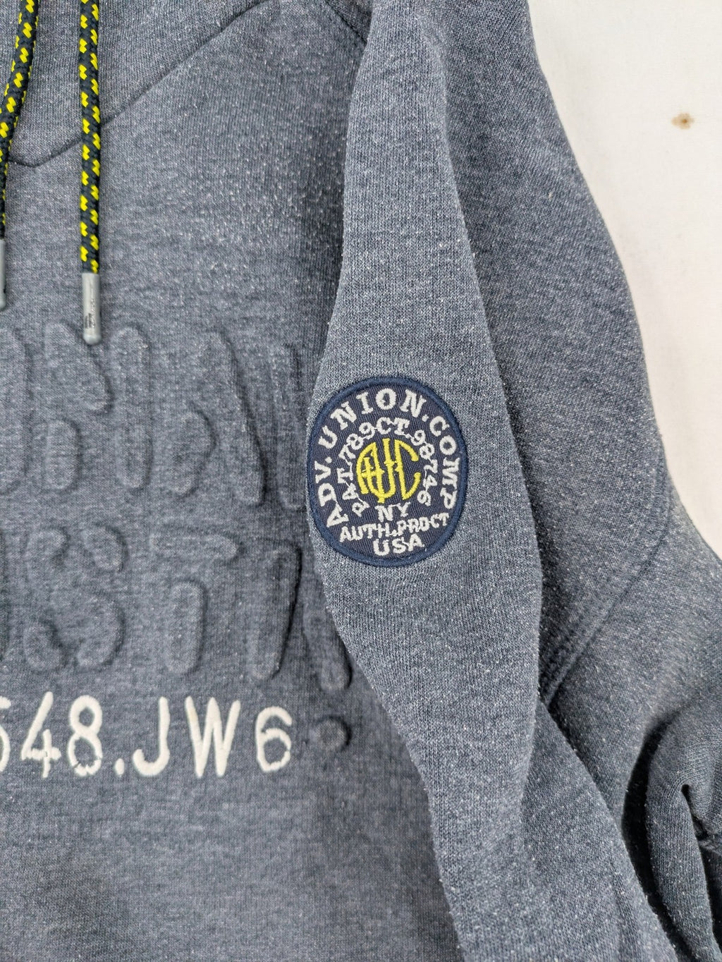 C&A grey hoodie with embossed chest logo, teddy-lined hood, and side zip pockets.