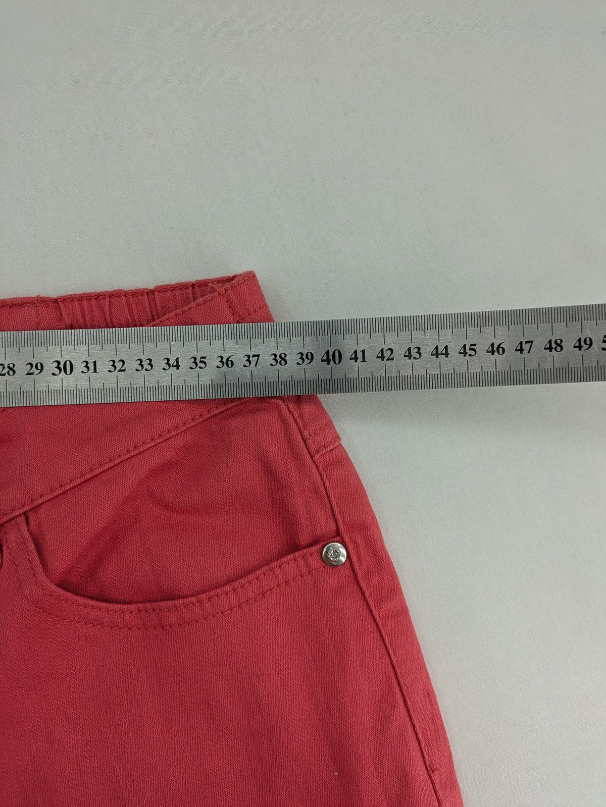 Helena Vera red straight jeans with elastic waistband and rhinestone details on pockets.