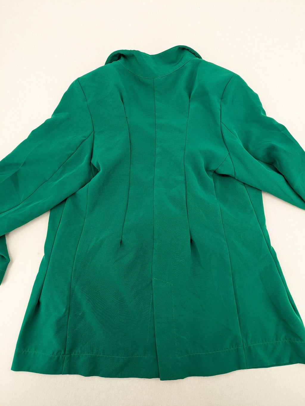 Promiss green blazer jacket single-button design with notch lapels and decorative pockets.