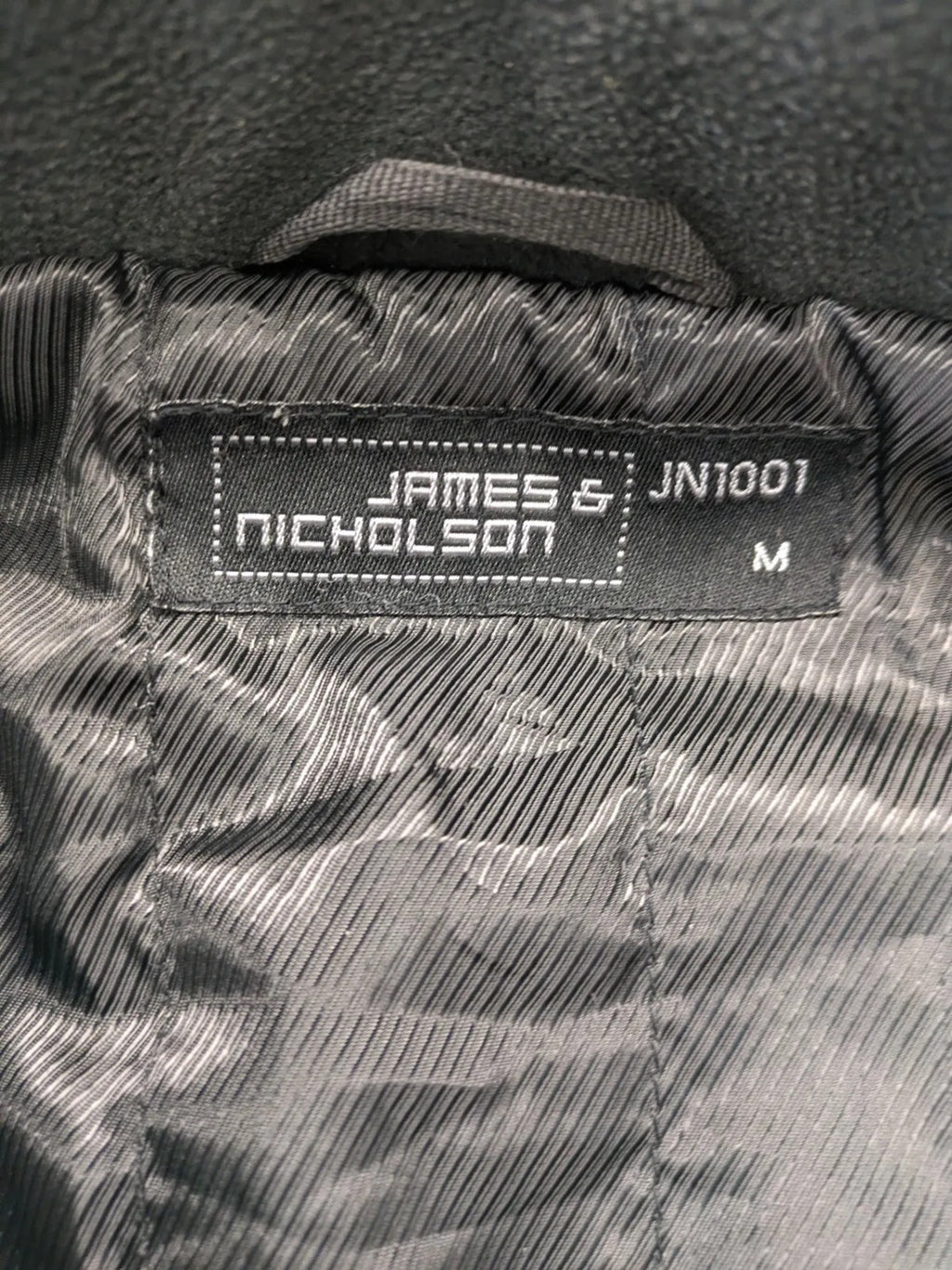 James & Nicholson grey softshell jacket with fleece lining and multiple zip pockets.