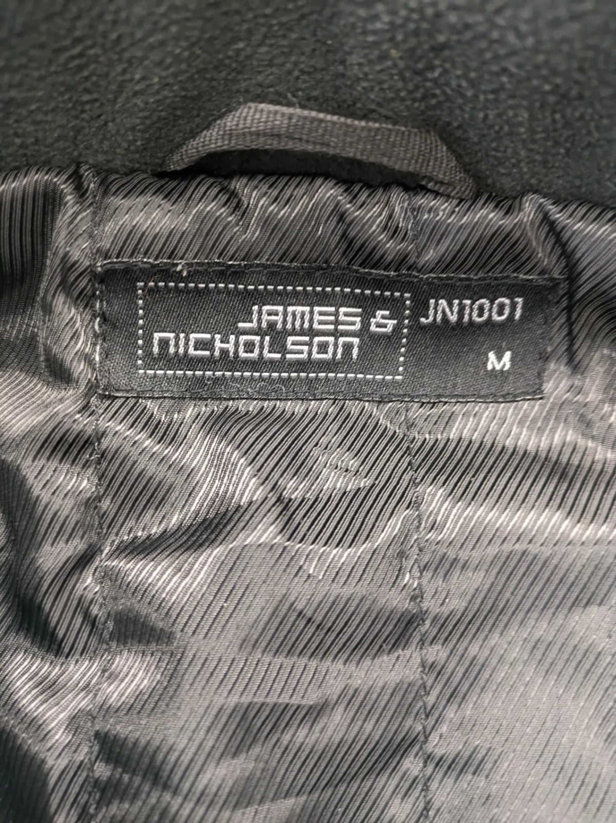 James & Nicholson grey softshell jacket with fleece lining and multiple zip pockets.