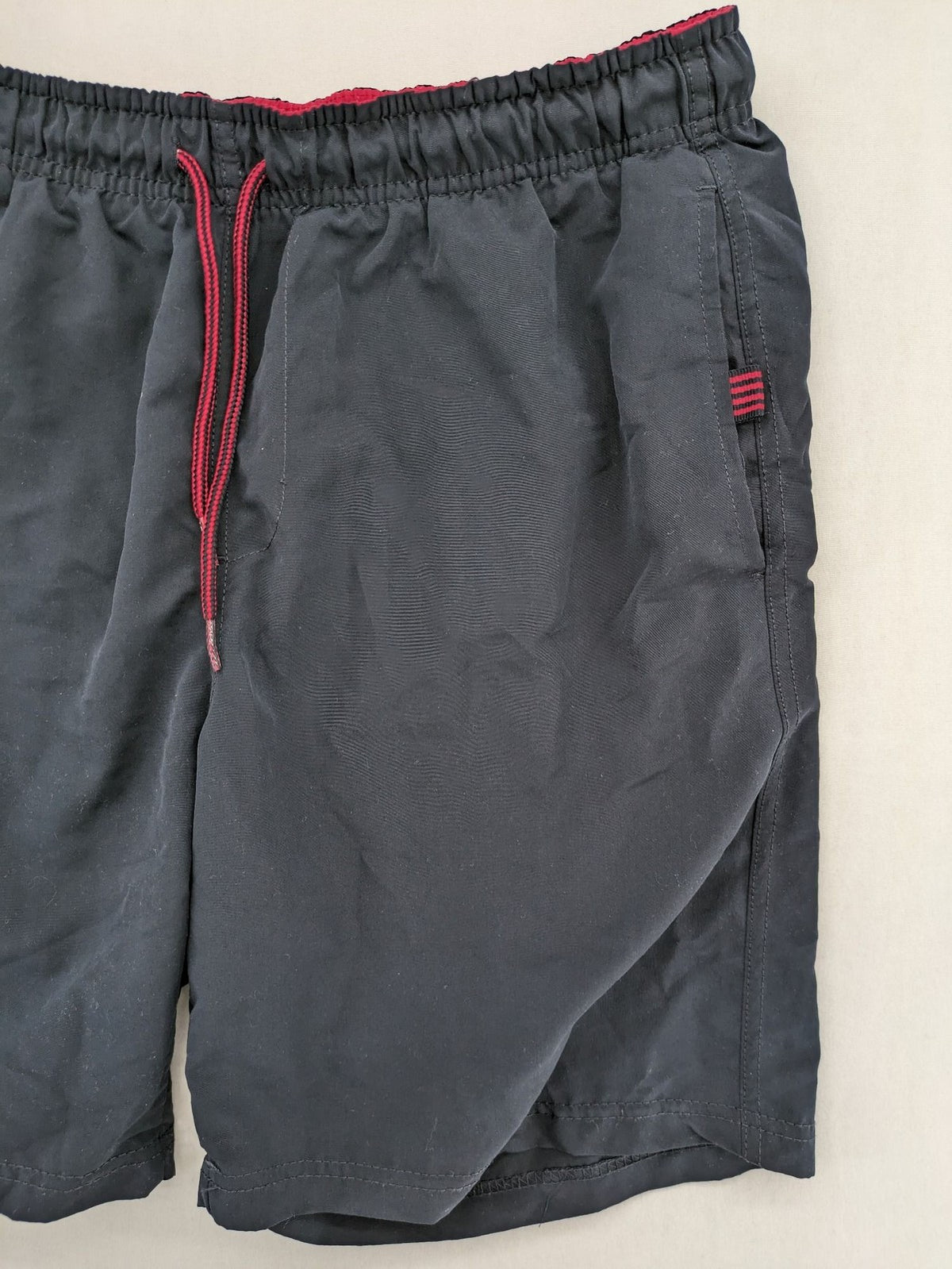 LC Waikiki navy swim shorts with red accents, elastic waistband, and quick-dry material.