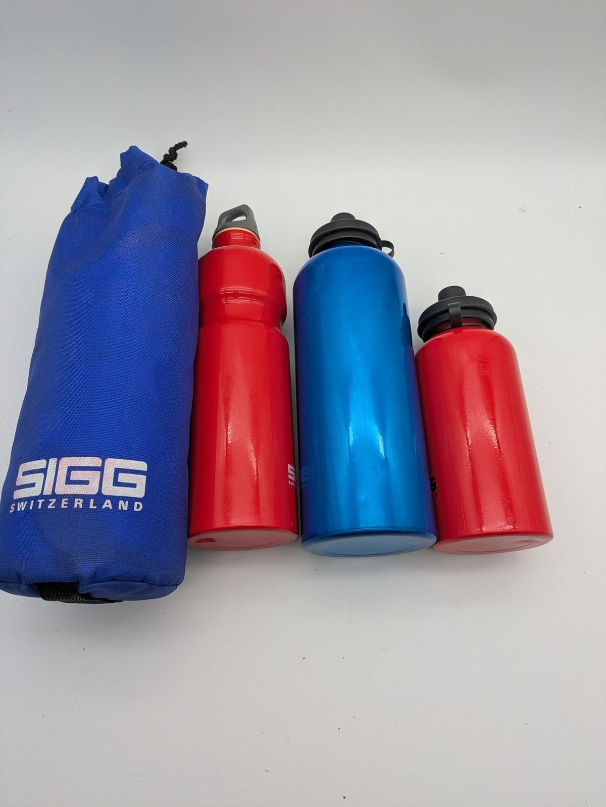 SIGG blue thermos set with red accents, durable aluminum, stylish outdoor design.