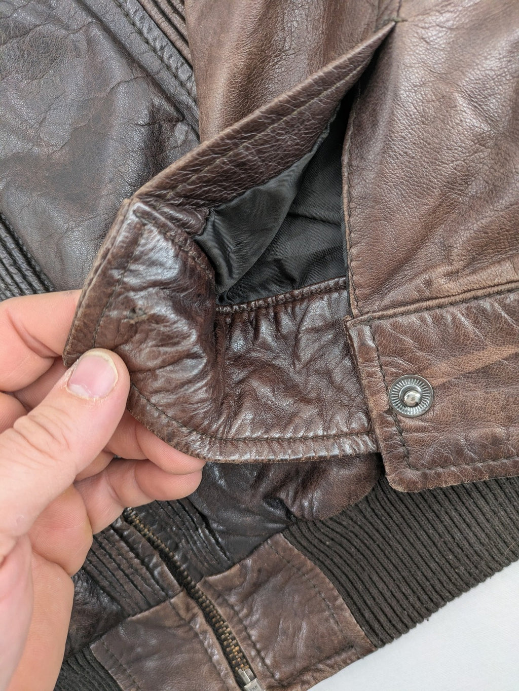 H&M green leather bomber jacket with ribbed collar and moto-style padding.
