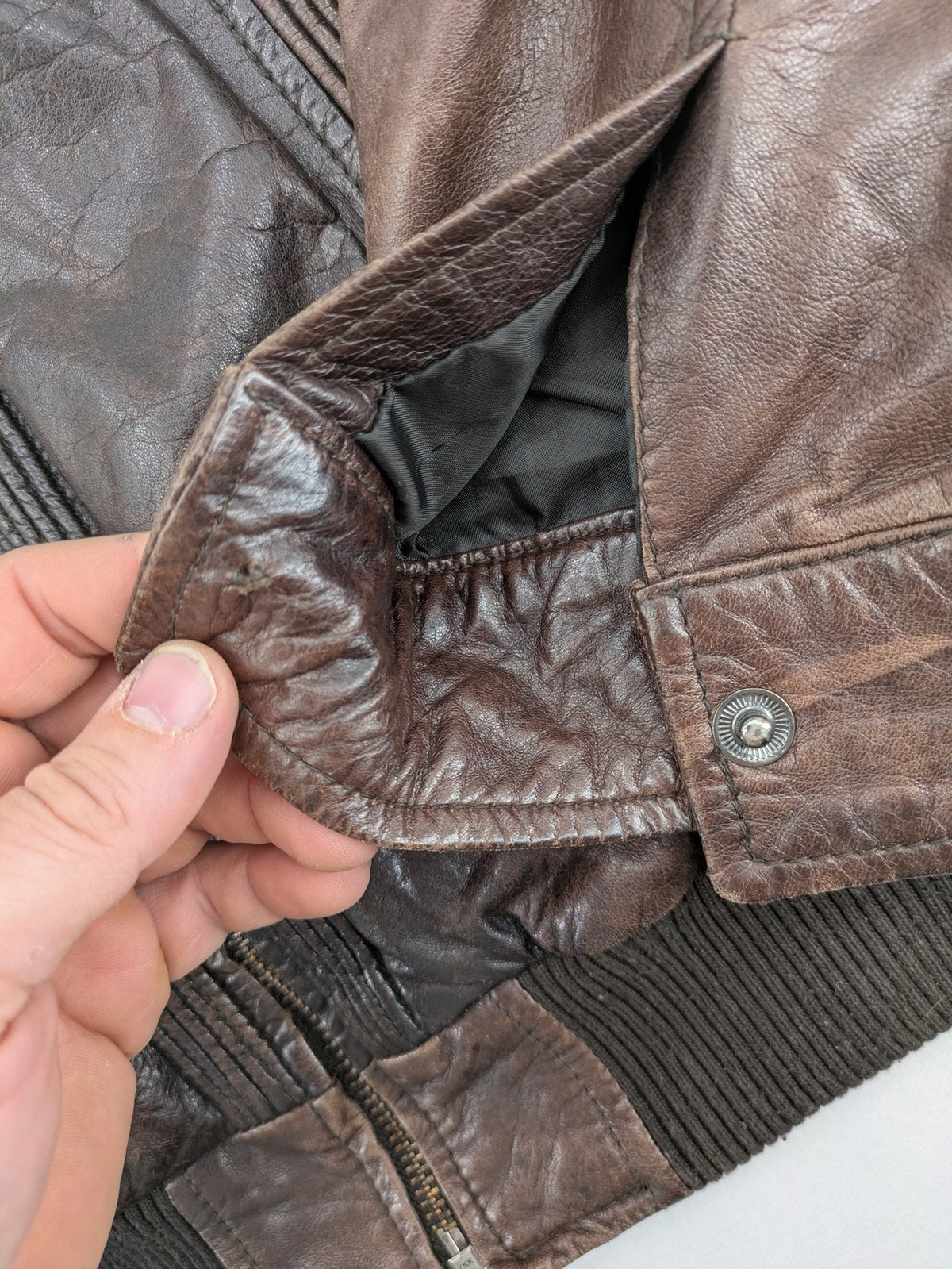 H&M green leather bomber jacket with ribbed collar and moto-style padding.