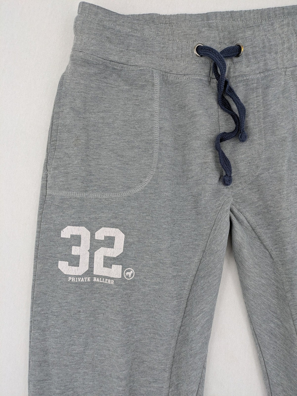 Private Baller grey sweatpants with "32" graphic print and blue drawstring.