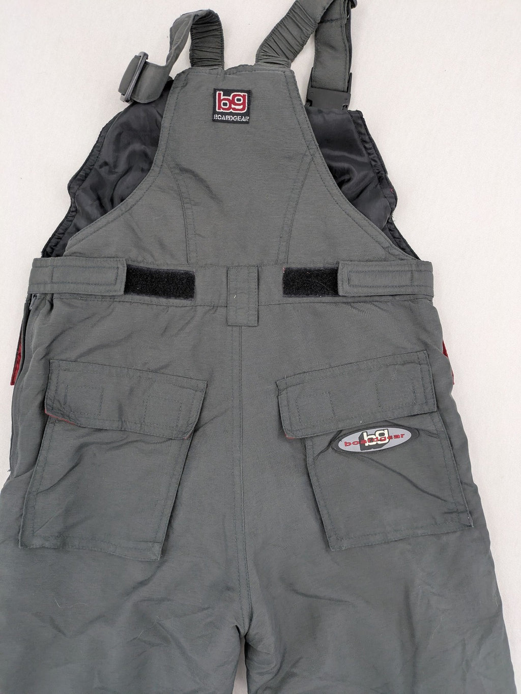 H&M grey snow pants with red accents, adjustable straps, and multiple cargo pockets.