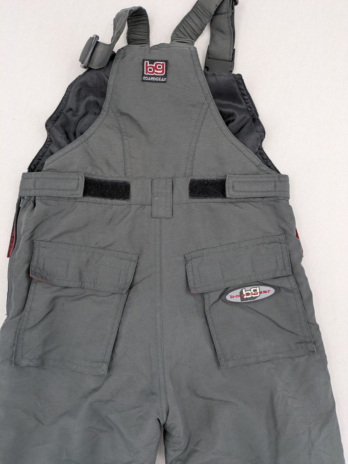 H&M grey snow pants with red accents, adjustable straps, and multiple cargo pockets.