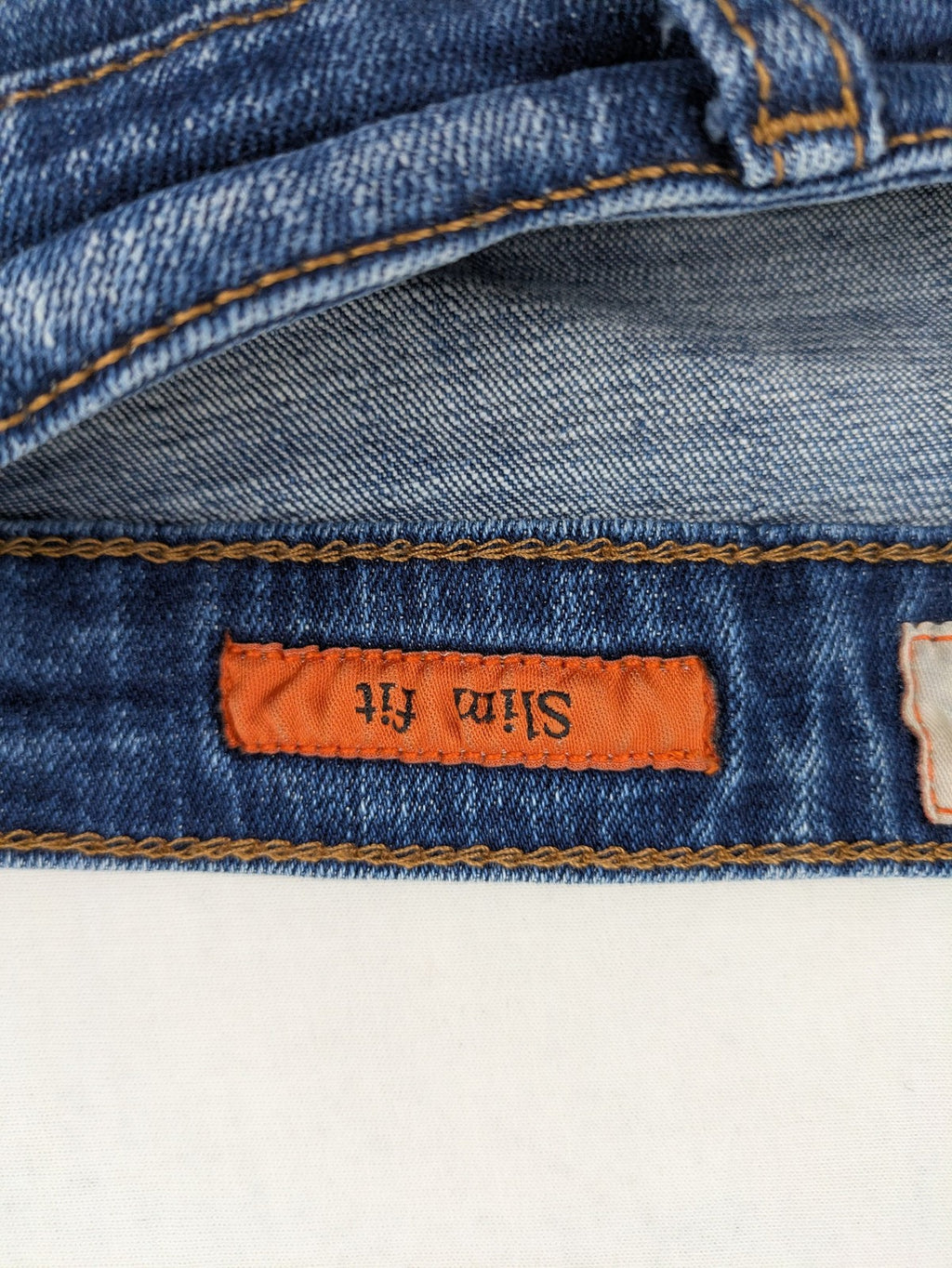 ICON 2 blue slim fit jeans distressed stretch denim with button fly and faded details.