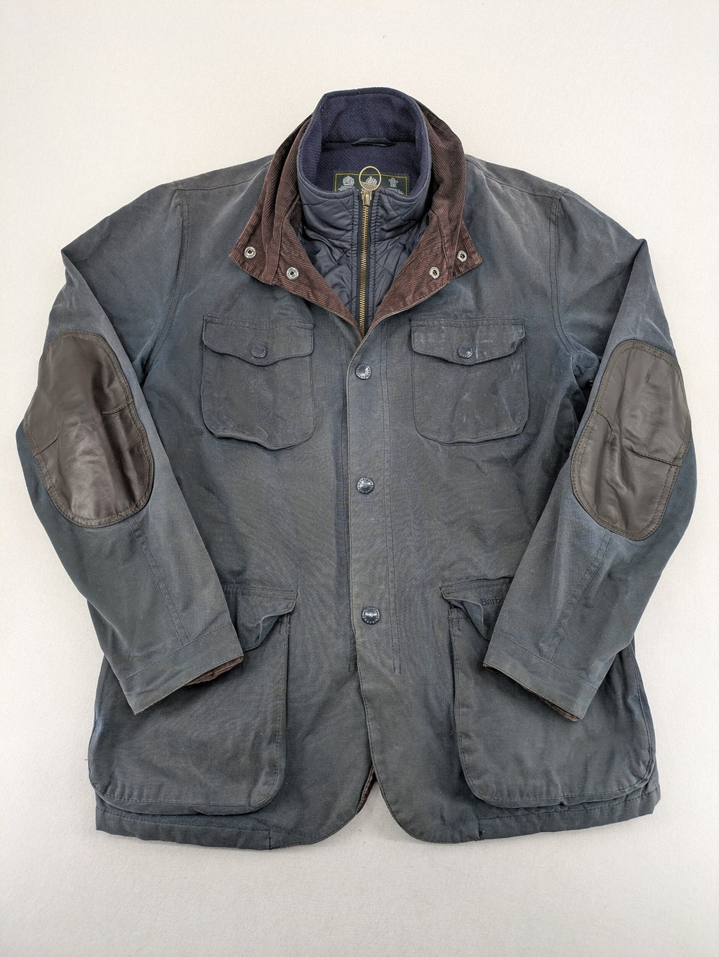 Barbour navy wax jacket with quilted lining and leather elbow patches, tartan interior.