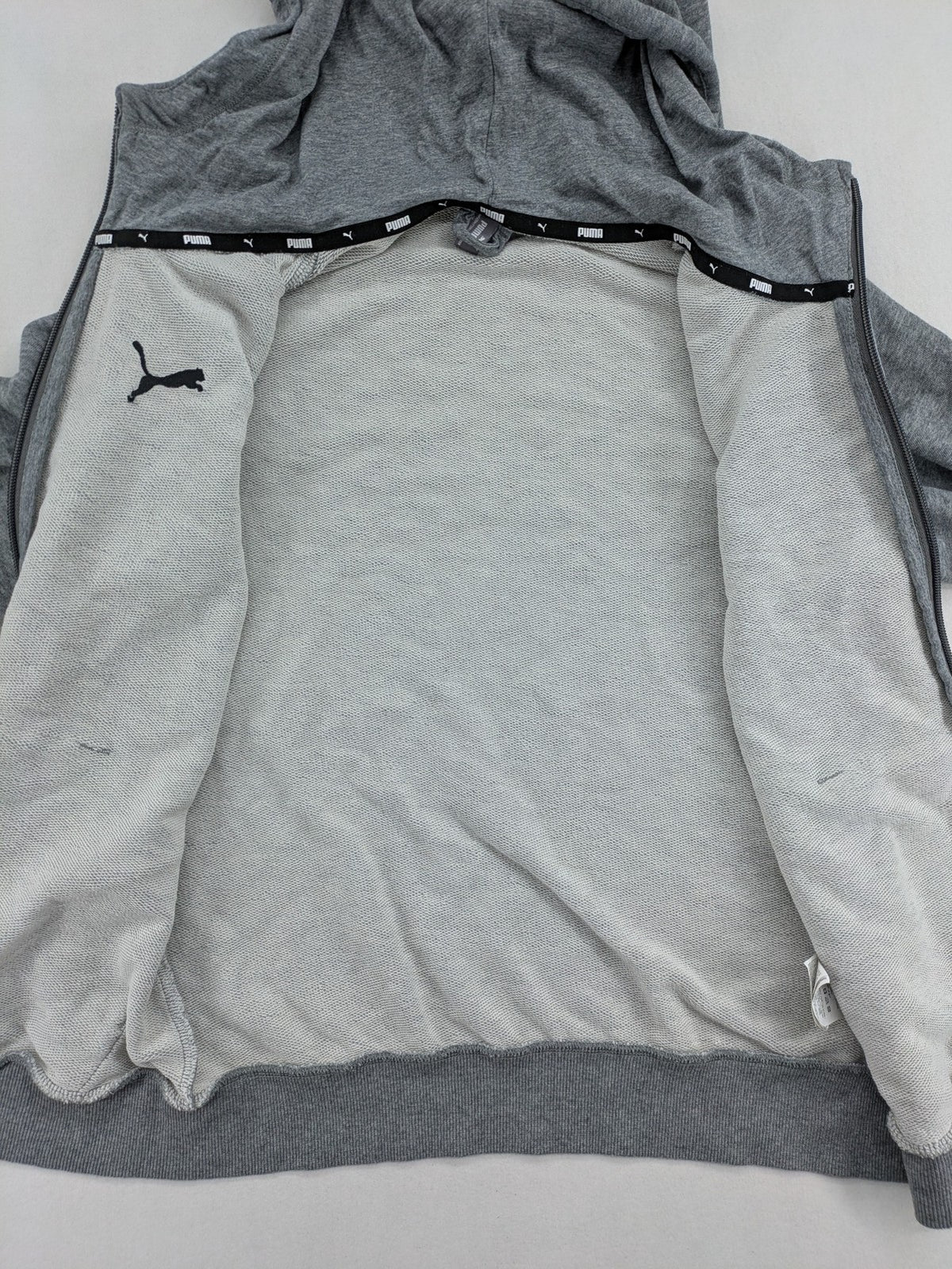 Puma grey full zip hoodie with adjustable drawstring hood and logo detail.