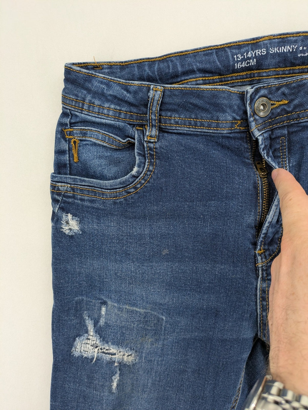 Denim & Co. blue skinny jeans with distressed ripped details and adjustable waistband.