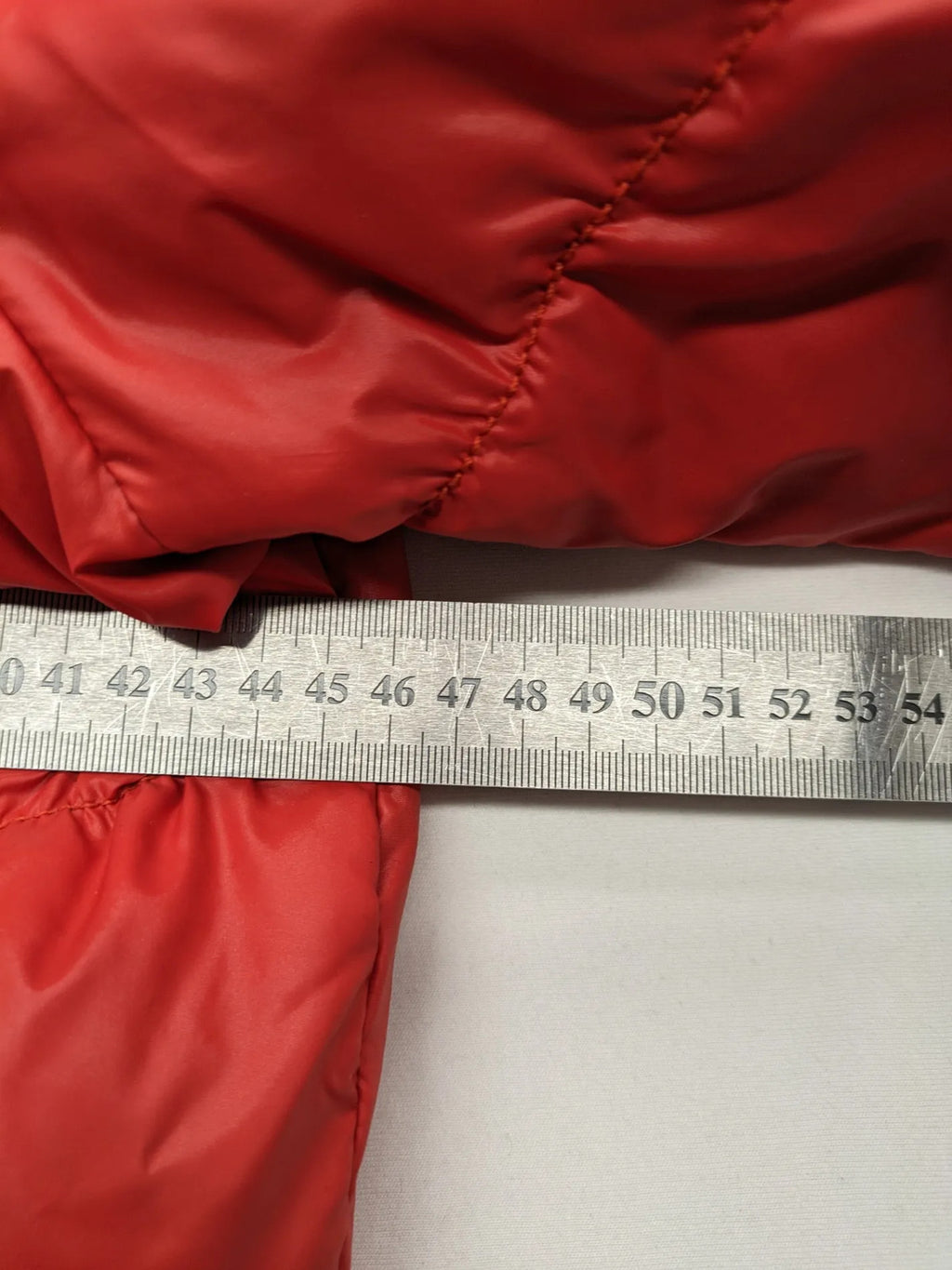 Hilfiger Denim red down jacket with quilted design, stand collar, and zip closure.