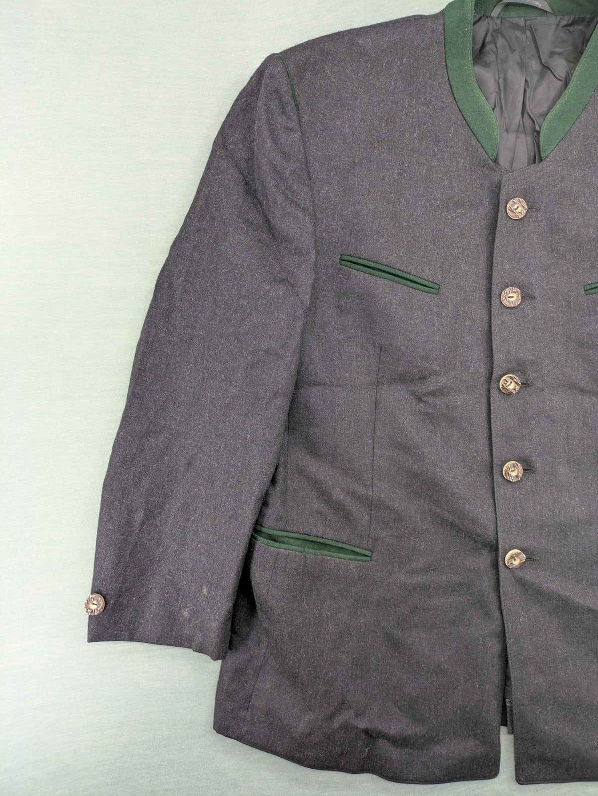 Rofan Tracht grey jacket with green stand-up collar and pockets, made from 100% wool.