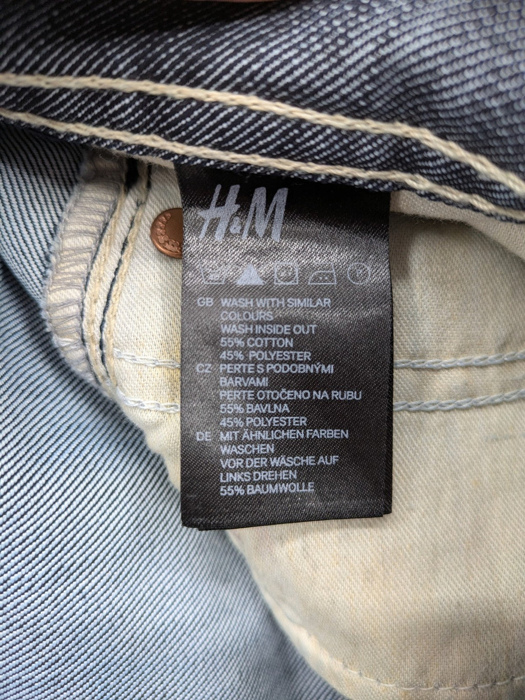 H&M blue denim shorts with rolled cuffs and back patch pockets, mid-rise fit.