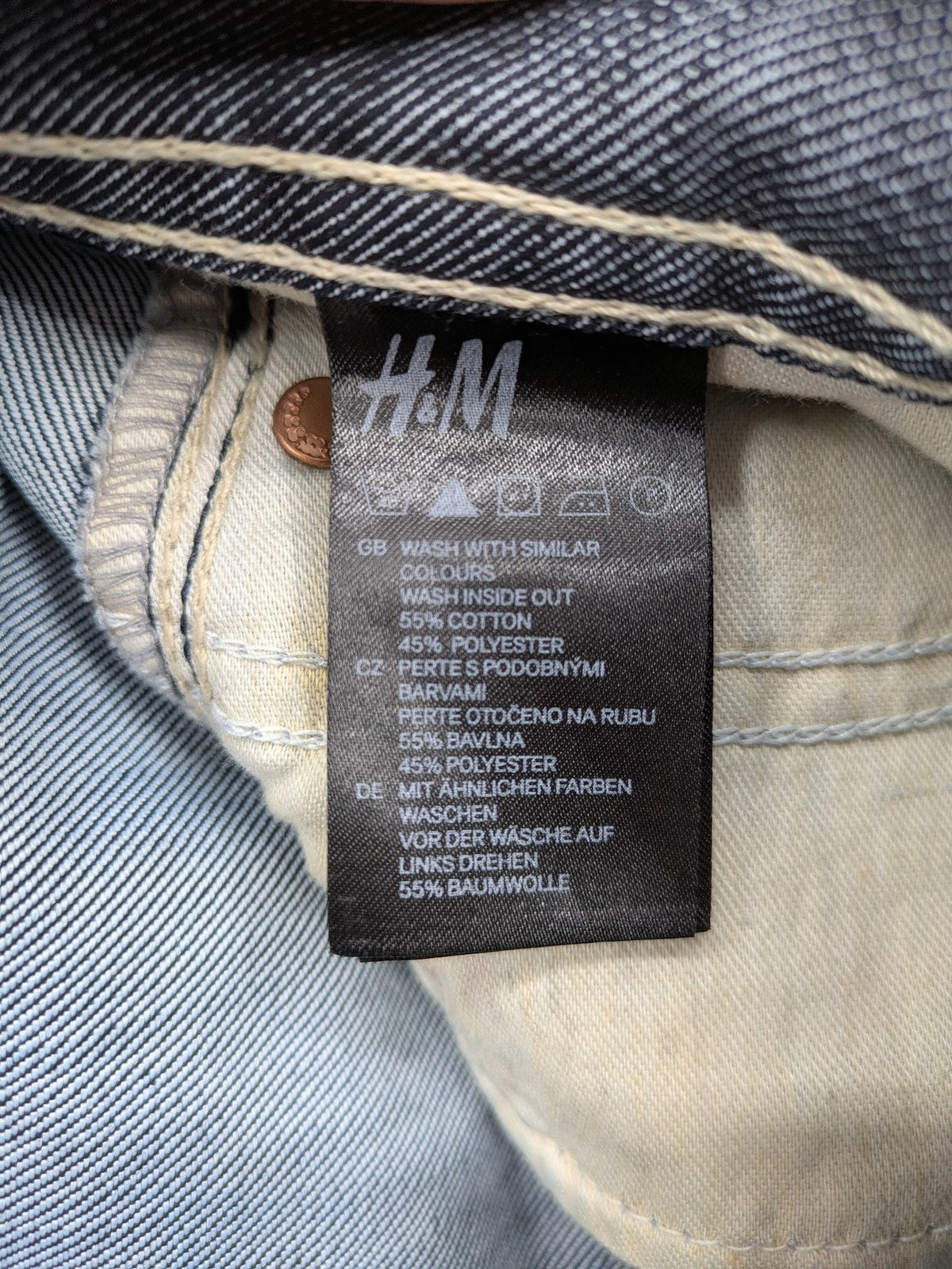 H&M blue denim shorts with rolled cuffs and back patch pockets, mid-rise fit.