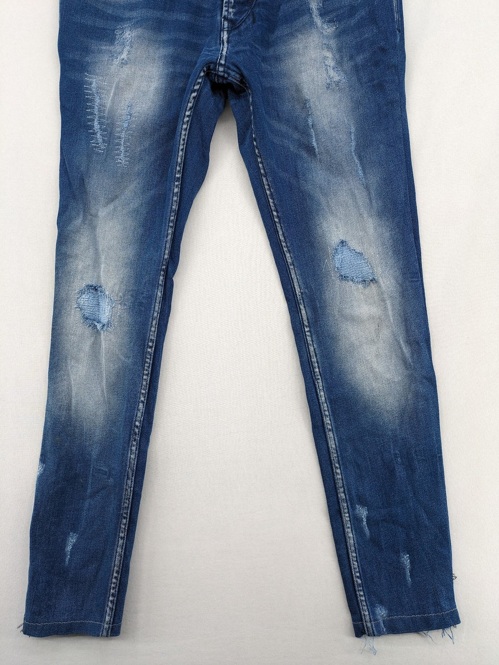 Diesel blue straight jeans with distressed details and ripped accents, made of cotton.