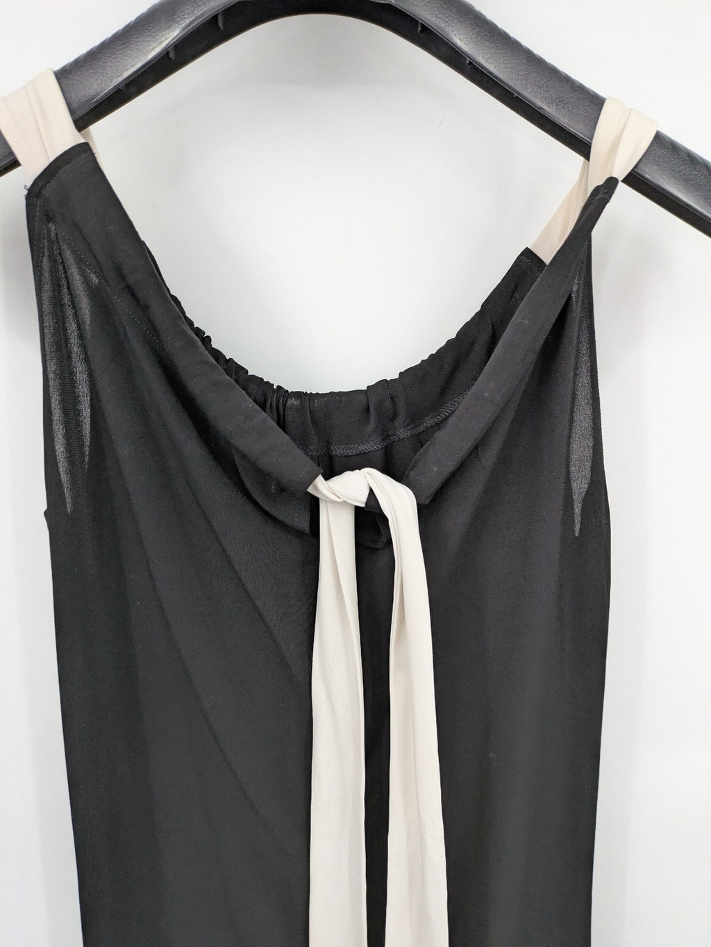 En Focus Studio beige and black top, sleeveless with beaded neckline and tie detail.