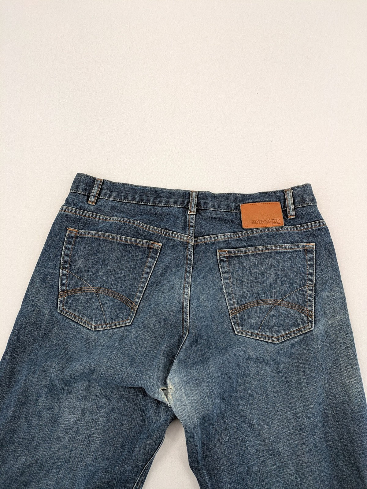Indygo blue straight jeans 5-pocket style with subtle red pocket detail, cotton material.