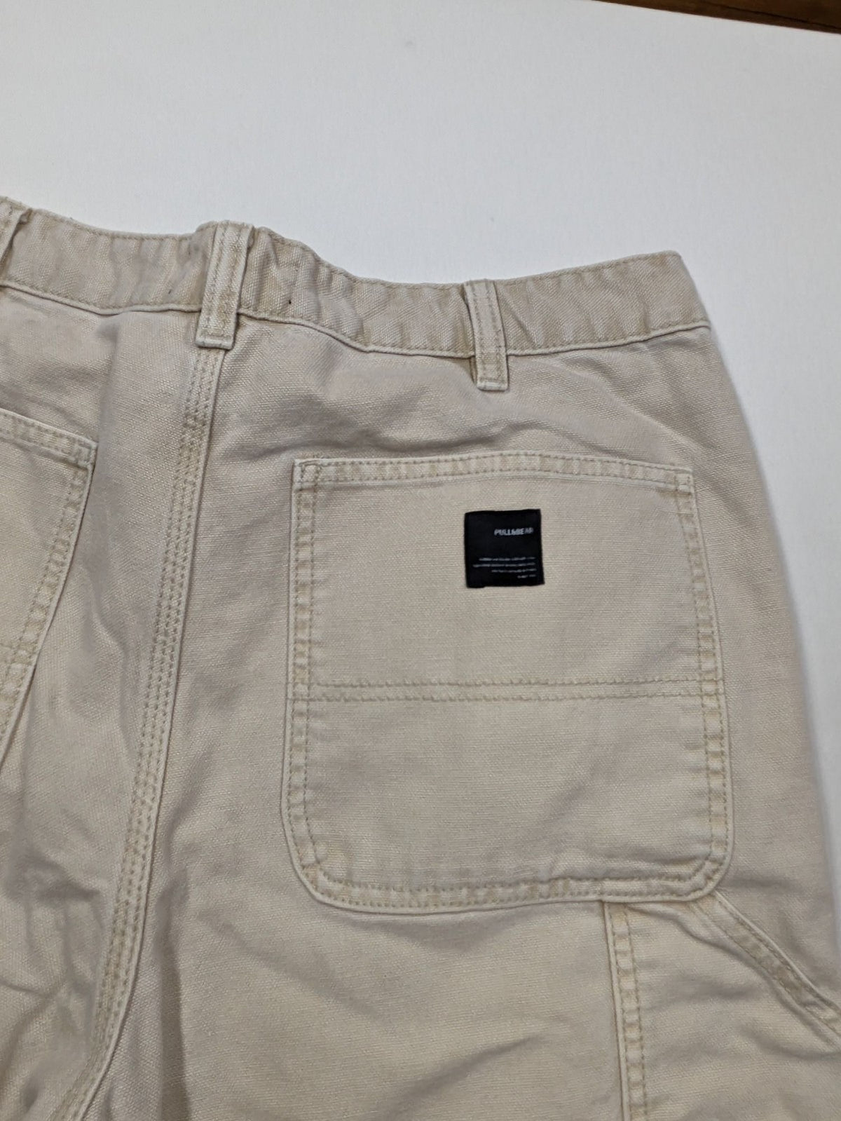 Pull&Bear beige carpenter pants with classic zipper, belt loops, and durable cotton material.
