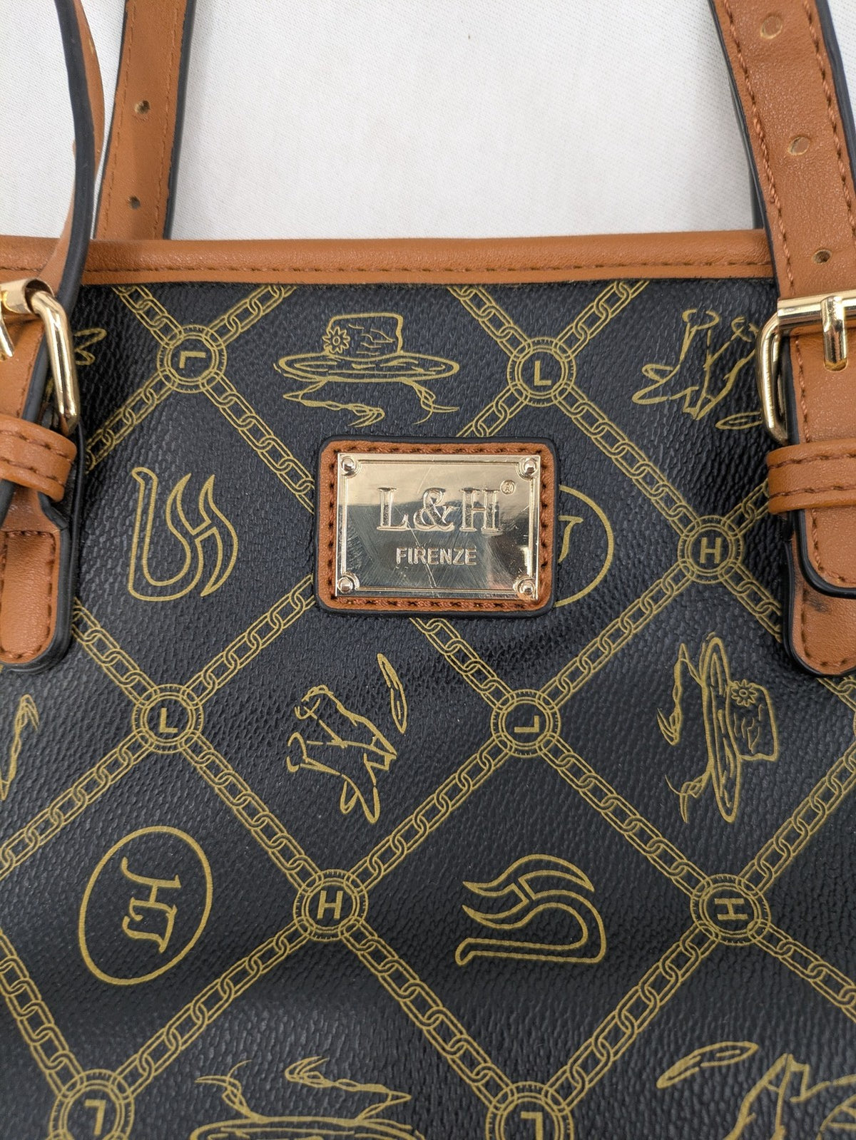 L&H brown and black handbag with monogram pattern and gold accents, versatile shoulder strap.