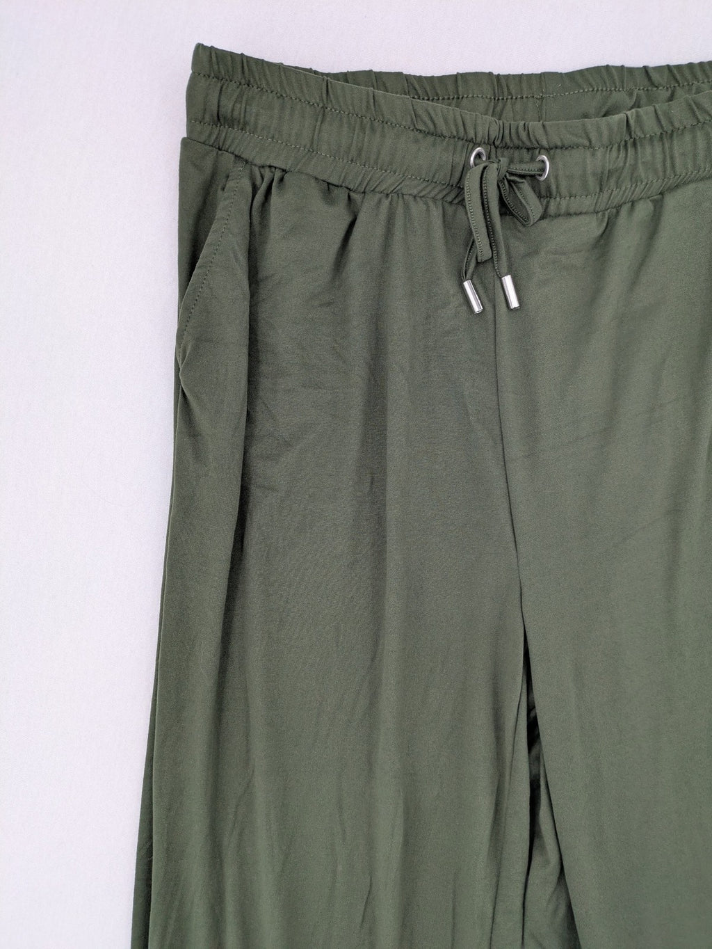 Infinity green jogger pants with elastic waistband and side pockets, soft stretch material.