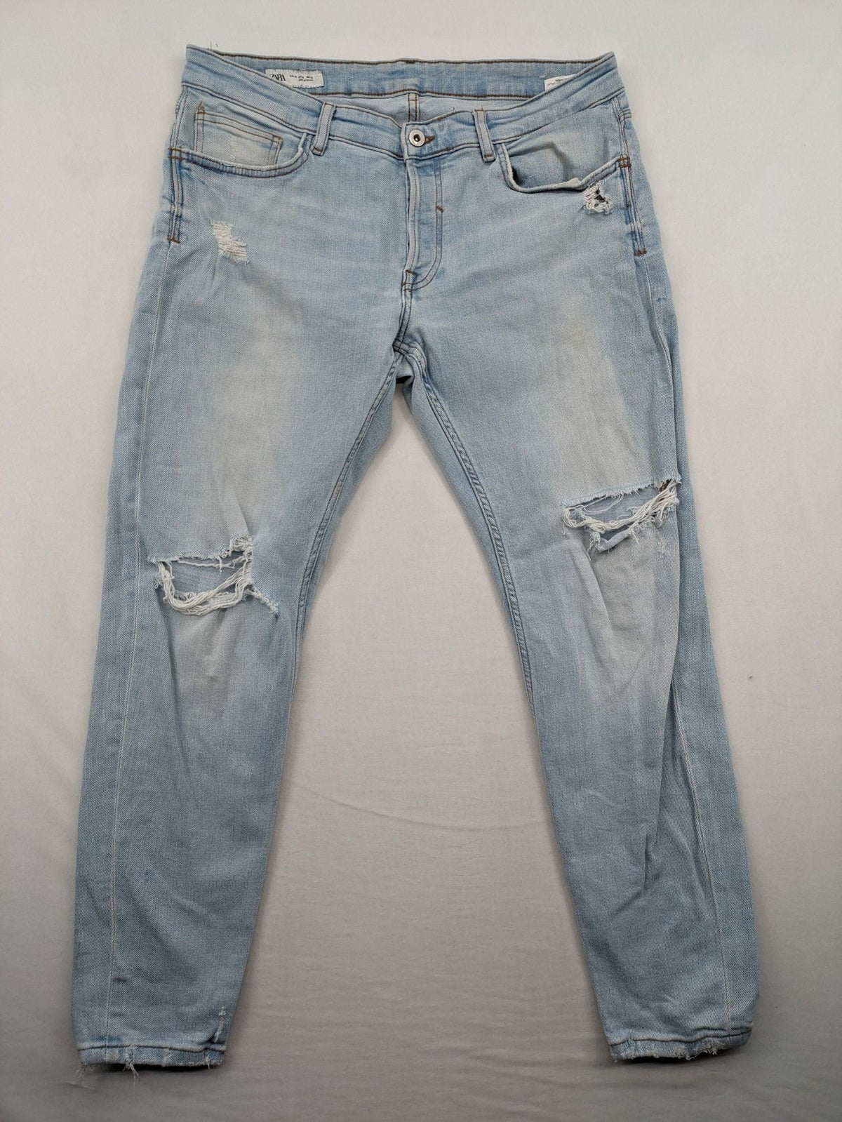 Zara blue straight jeans with distressed knees and classic button fly.
