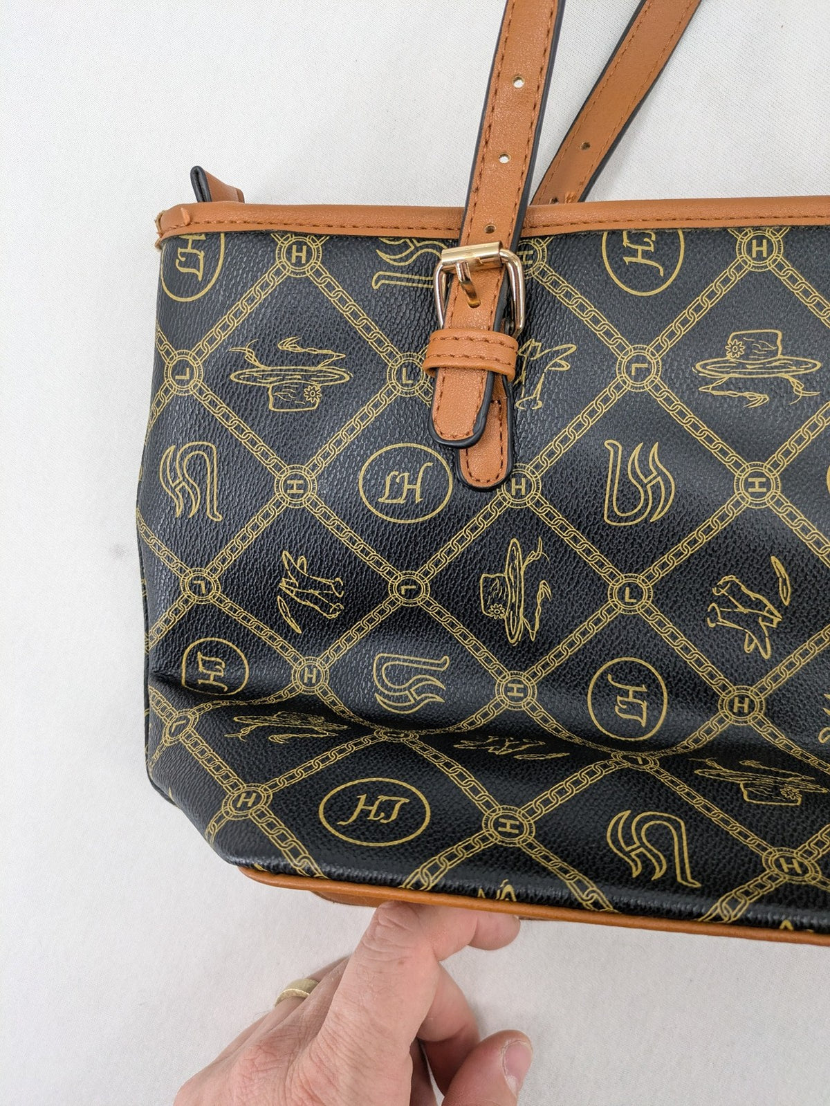 L&H brown and black handbag with monogram pattern and gold accents, versatile shoulder strap.