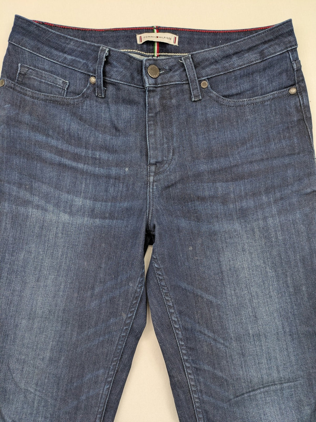 Tommy Hilfiger blue straight jeans with iconic logo and dark wash denim finish.