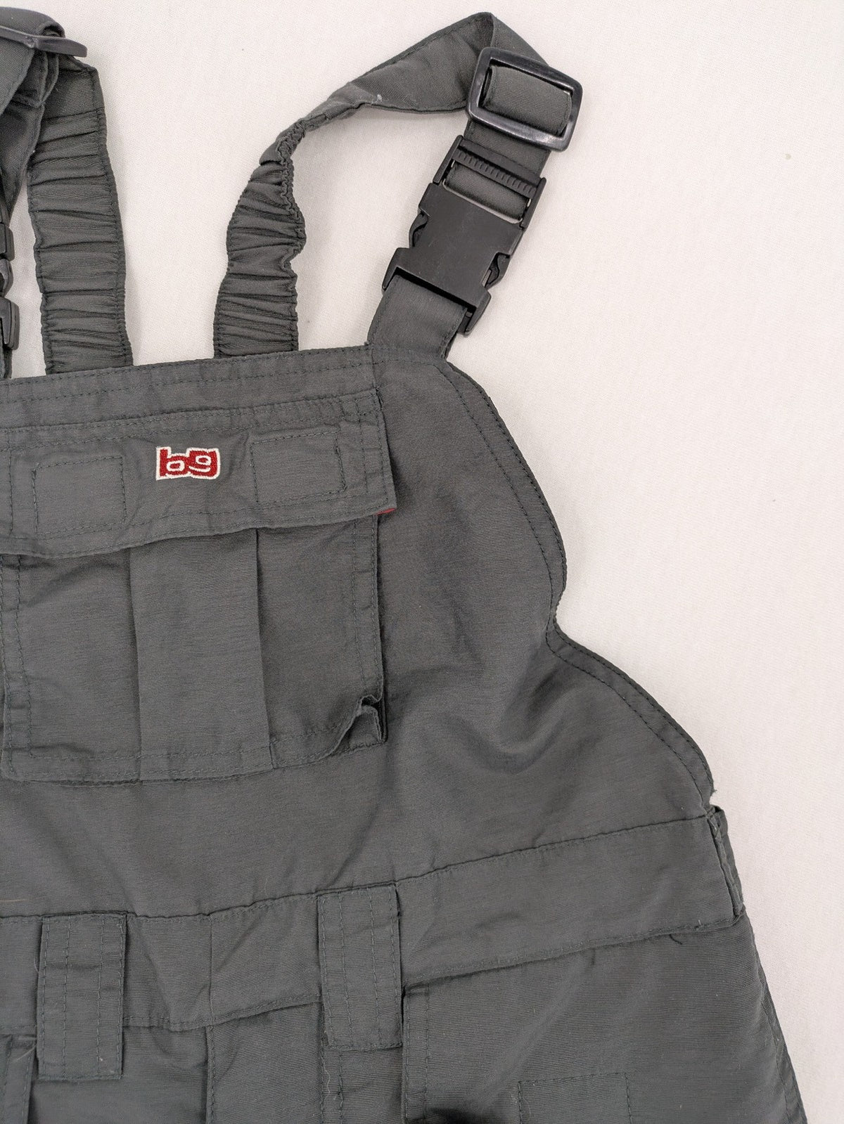H&M grey snow pants with red accents, adjustable straps, and multiple cargo pockets.