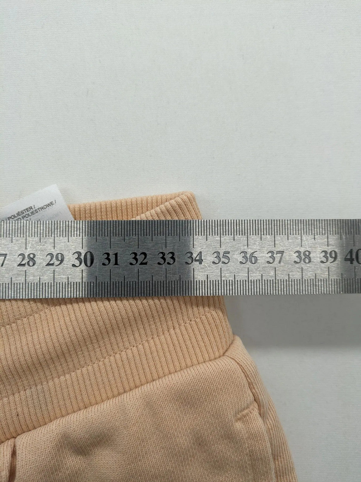 Hummel beige jogging pants with adjustable drawstring, embroidered logo, and ankle cuffs.