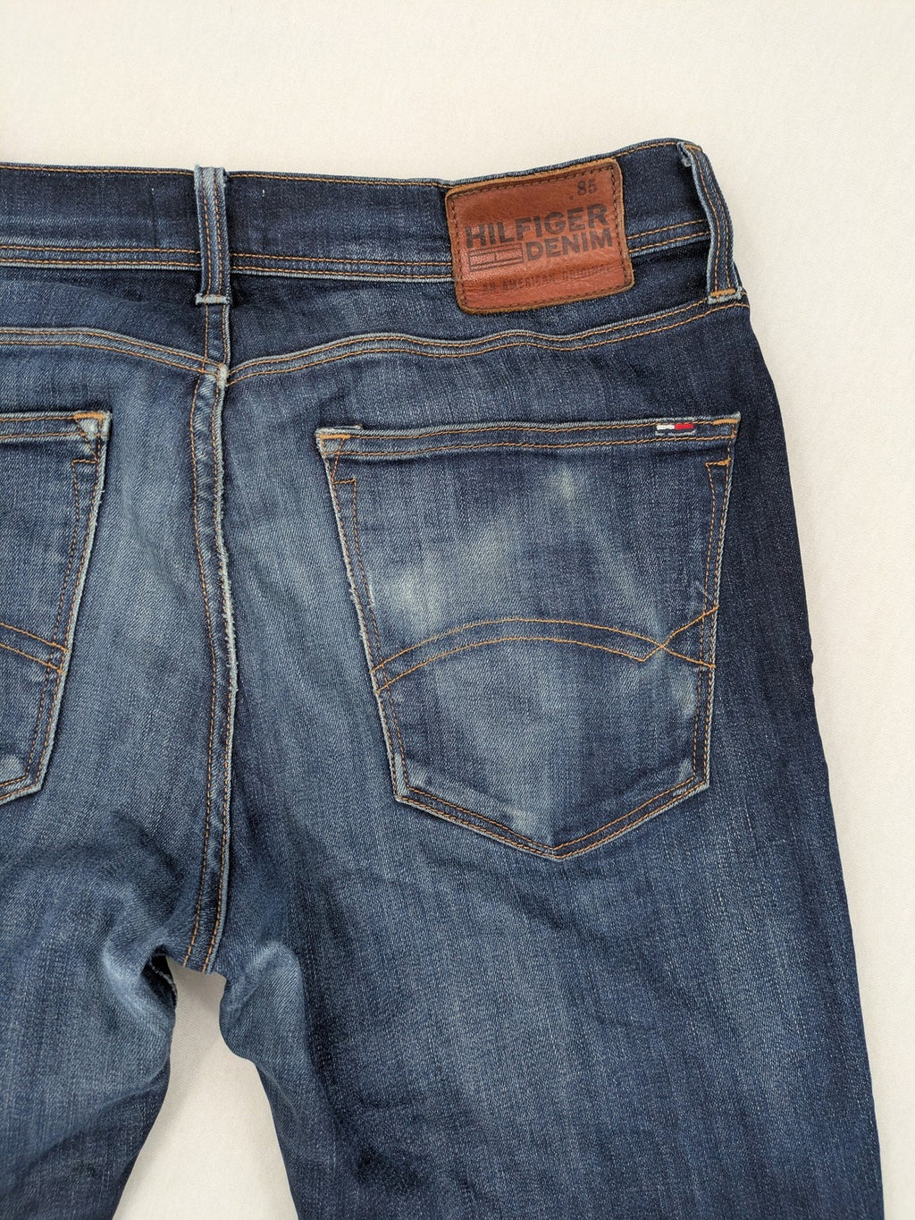 Tommy Hilfiger Denim blue straight jeans with five-pocket design and natural fading details.