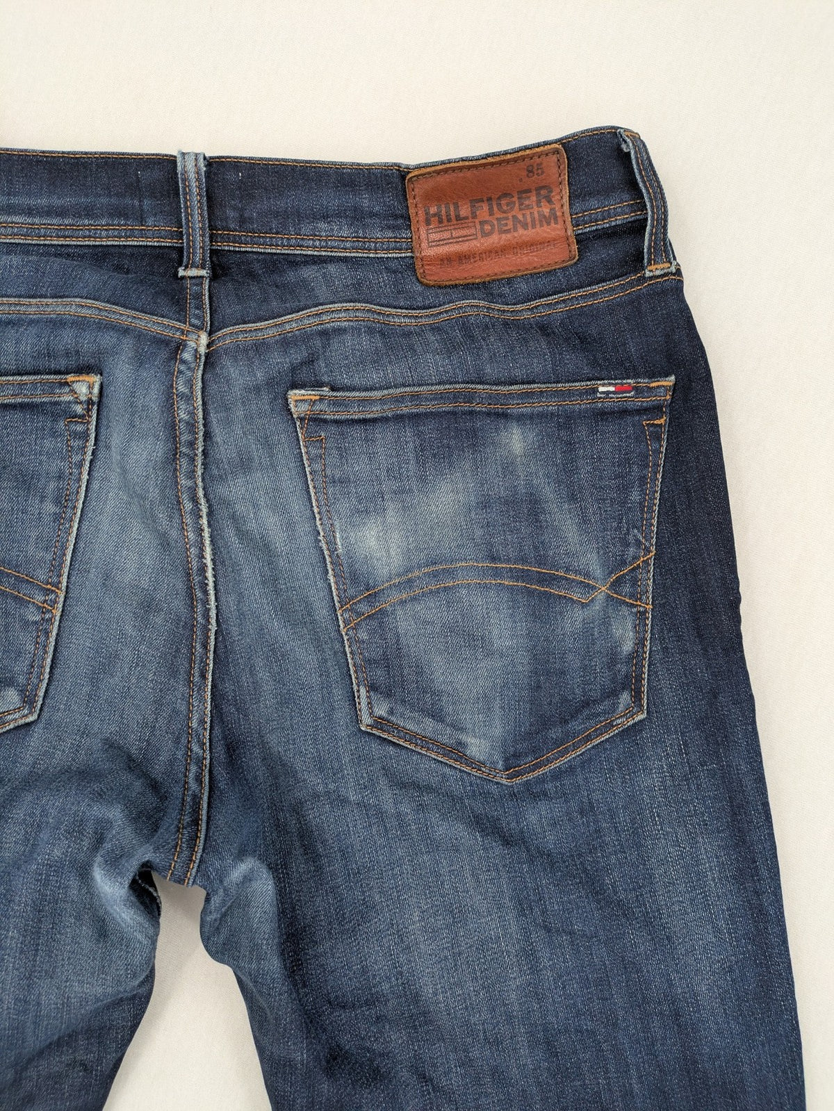 Tommy Hilfiger Denim blue straight jeans with five-pocket design and natural fading details.