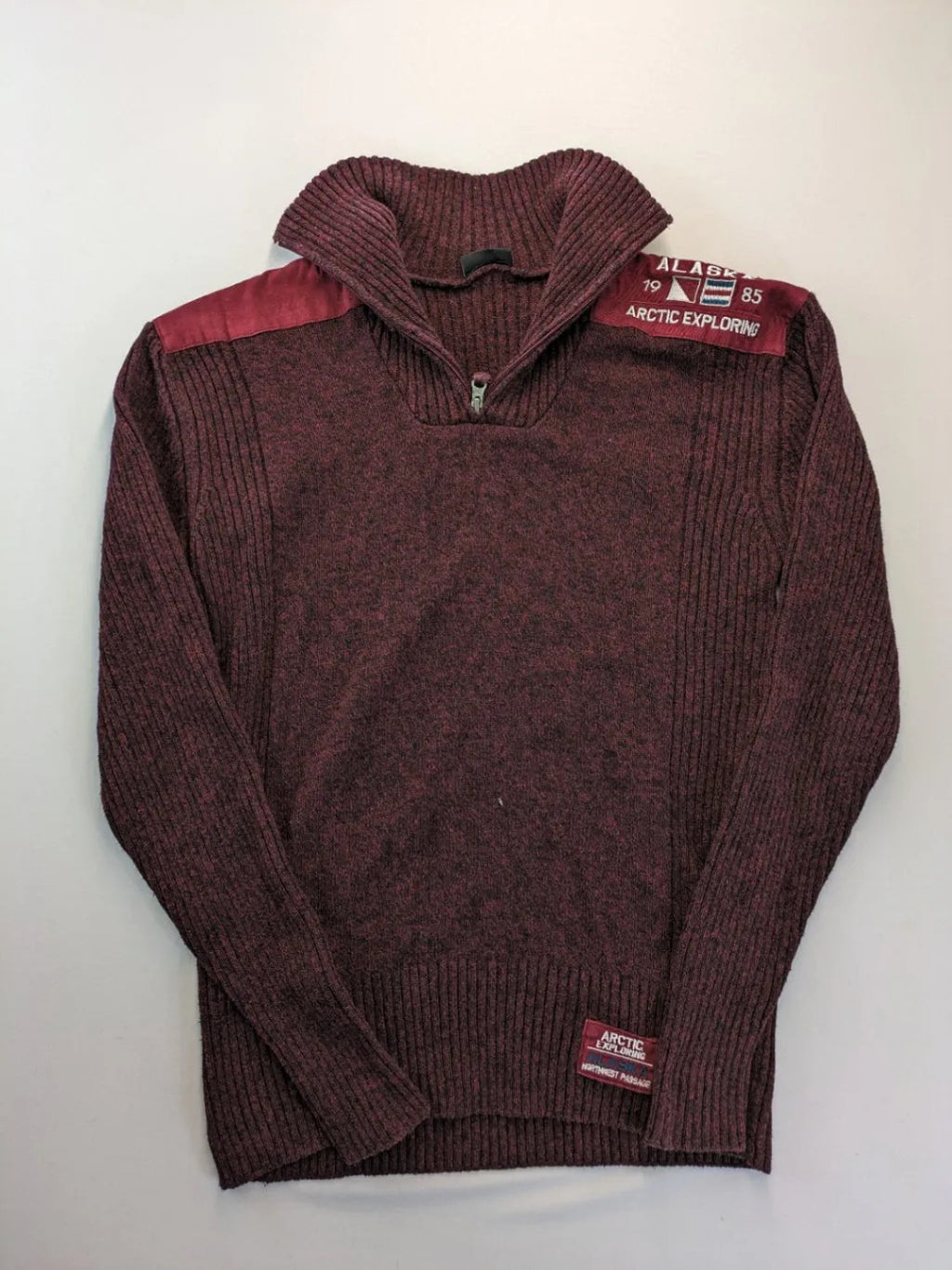 Infinity burgundy turtle neck jumper with quarter-zip and ribbed knit texture.