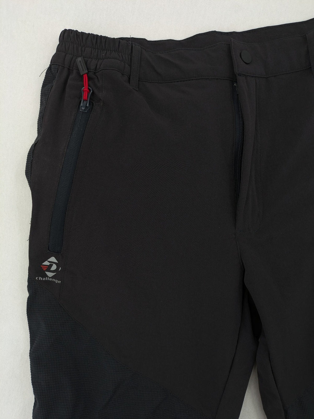 Outdoor black capri pants with elastic waistband and multiple zippered pockets.